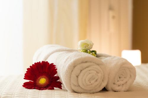 una toalla en una cama junto a una flor en Assago amazing flat, en Assago