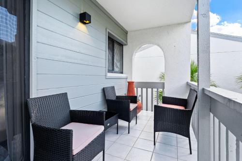 a balcony with chairs and a table on a building at Just Beachy By Beachside Management in Siesta Key