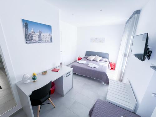 ein kleines Schlafzimmer mit einem Bett und einem Schreibtisch. in der Unterkunft Appartamento al centro storico in Caltagirone