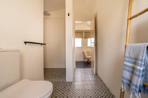 a bathroom with a toilet and a hallway at B&B Casa do Cerro in Moncarapacho