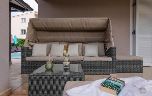 - un canapé en osier installé sur une terrasse avec une table dans l'établissement Beautiful Home In Loborika With Wi-fi, à Loborika
