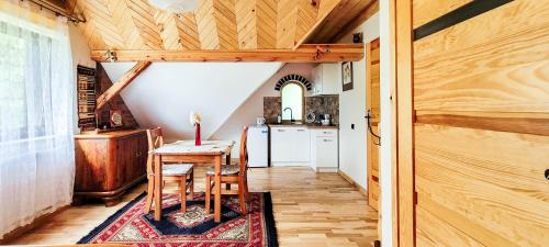 a dining room with a table and a kitchen at Gryglówka Noclegi in Zembrzyce