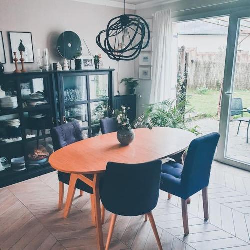 une salle à manger avec une table en bois et des chaises bleues dans l'établissement Maison familiale top Saint-Malo, à Saint-Malo