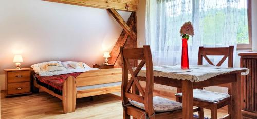 a bedroom with a bed and a table and chairs at Gryglówka Noclegi in Zembrzyce