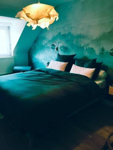 une chambre bleue avec un lit et une lampe dans l'établissement Maison familiale top Saint-Malo, à Saint-Malo