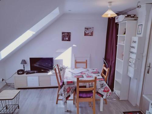 Cette chambre dispose d'une table, de chaises et d'un bureau. dans l'établissement APPARTEMENT COSY HYPER CENTRE, à Le Mont-Dore