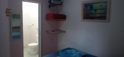 a bathroom with a shower and a toilet and a picture at Pousada Ribeirinha in Aparecida