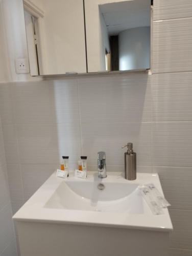 un lavabo blanc dans une salle de bain avec un miroir dans l'établissement Appartement 2 pièces rénover, à Nice