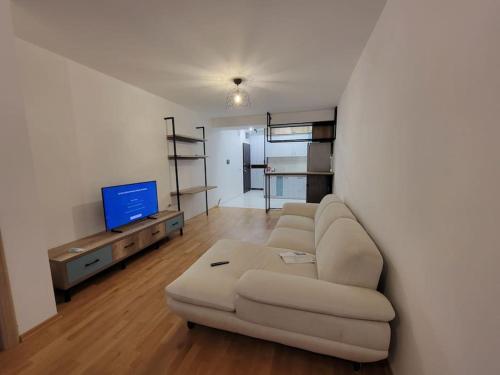 a living room with a couch and a flat screen tv at Brand new apartment in Downtown Gevgelija in Gevgelija
