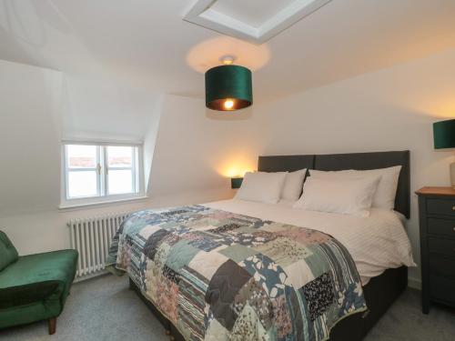 een slaapkamer met een bed, een stoel en een raam bij Mollys Cottage in Dorchester