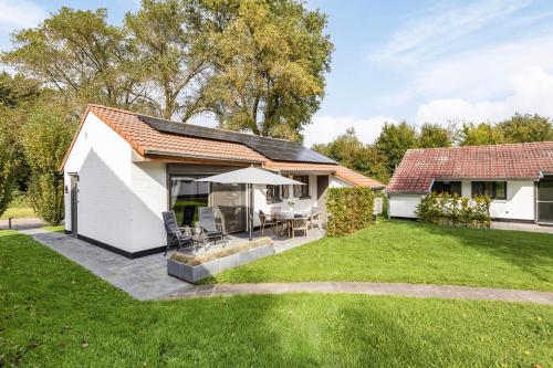 ein freistehendes Haus mit Terrasse und Rasen in der Unterkunft Casa Marit in Westouter