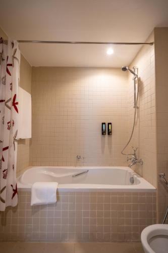 a bathroom with a bath tub and a toilet at INA HOMES - 2BHK Residences Tower 1 in Dubai