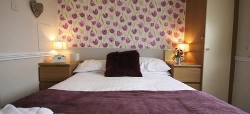 a bedroom with a bed with a purple blanket at The Blenheim Mount Hotel in Blackpool