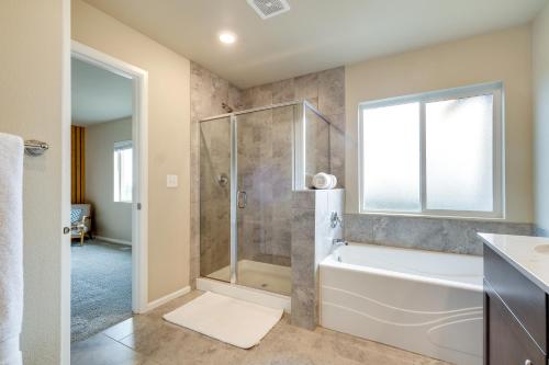een badkamer met een bad en een douche met een raam bij Bremerton Vacation Rental with Grill and Fire Pit in Bremerton