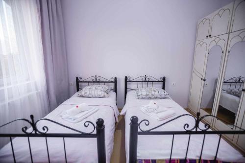 2 Einzelbetten in einem Zimmer mit Fenster in der Unterkunft Apartment Kutaisi 248 in Kutaissi