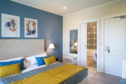 a bedroom with a large bed with blue walls at Hotel Rivage Taormina in Taormina