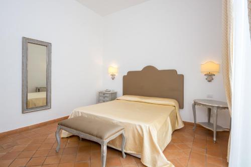 a bedroom with a bed and a table and a mirror at Relais San Giacomo in Maiori