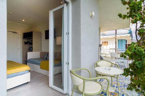 a room with a balcony with a bed and a table and chairs at Hotel Rivage Taormina in Taormina