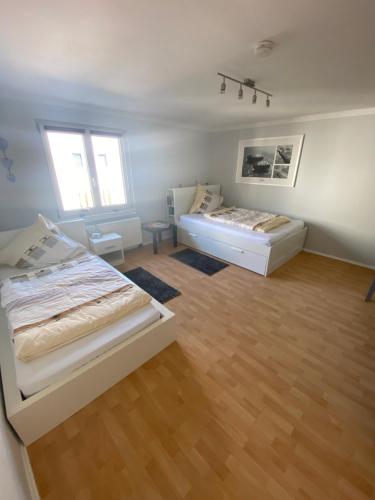 two beds in a room with wooden floors at Casa Türk in Bad Nauheim