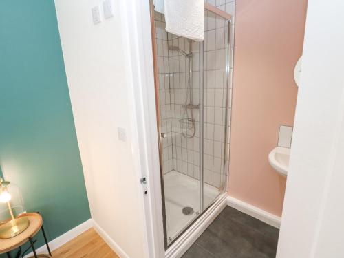 a shower with a glass door in a bathroom at James' Place in Falmouth