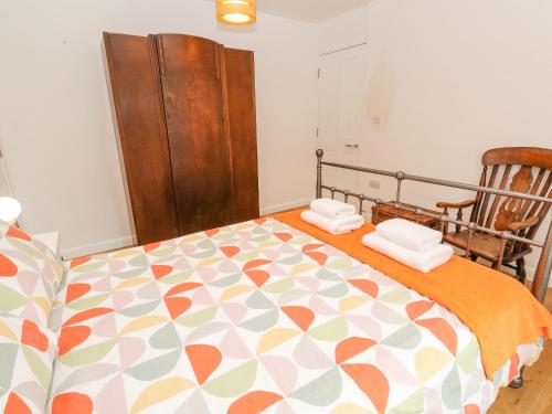 a bedroom with a bed with a orange and white blanket at James' Place in Falmouth