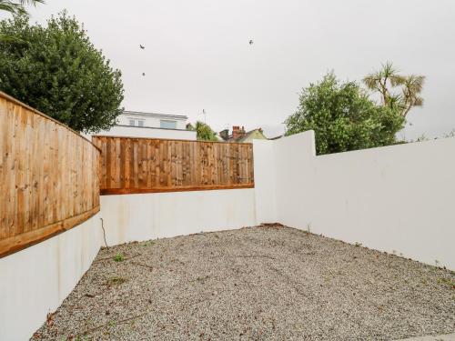 a white fence with a wooden gate in a yard at James' Place in Falmouth