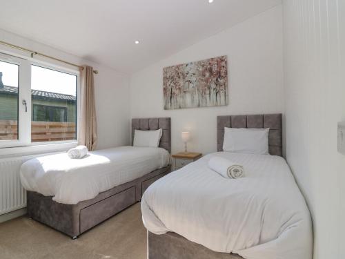 1 dormitorio con 2 camas y ventana en Lodge 16 - The Ericht Family, en Perth