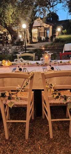 a wooden table with chairs and a table set for a meal at Tenuta Terre di Bosco Oasi di Relax nel Cilento in San Giovanni a Piro