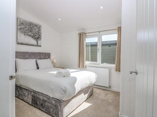 a bedroom with a large bed with two towels on it at Lodge 17 - Rannoch Family in Perth