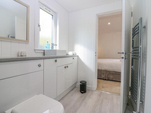 Baño blanco con lavabo y aseo en Lodge 17 - Rannoch Family, en Perth