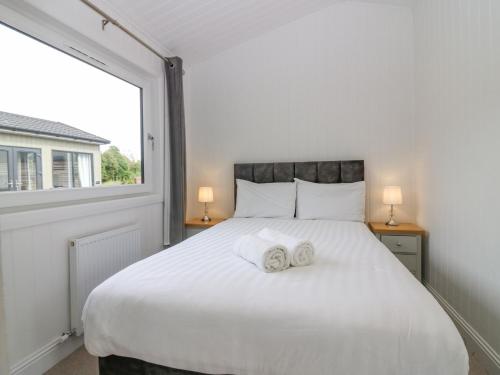 a bedroom with a large white bed with towels on it at Lodge 18 - Ruthven Hideaway in Perth