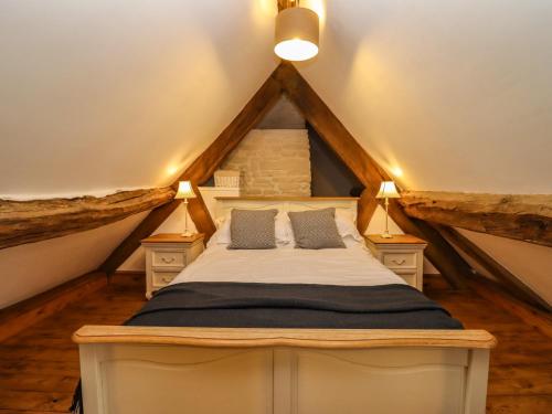 a bedroom with a bed in the attic at 1 White House Cottages in Ross on Wye