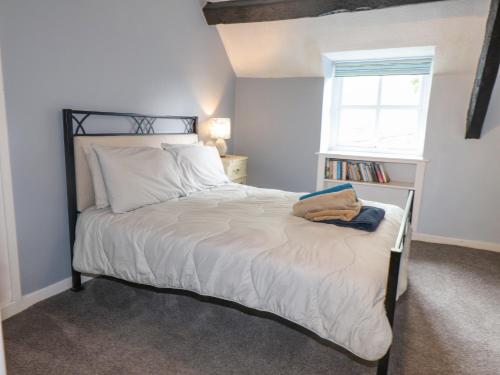 1 dormitorio con 1 cama con sábanas blancas y ventana en Ewyn Y Mor en Beaumaris