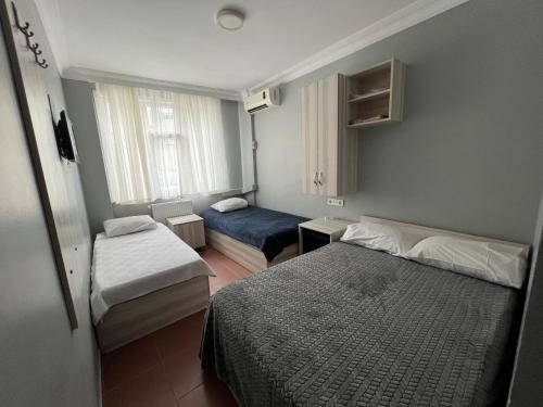 イスタンブールにあるHotel Primaのベッド2台と窓が備わる小さな客室です。