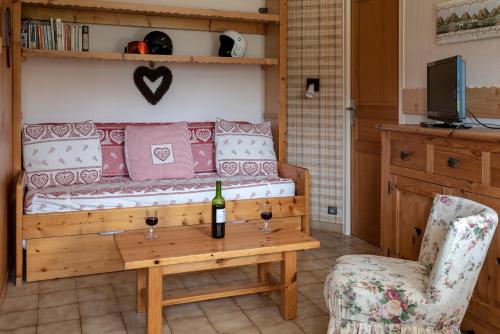- un salon avec un canapé et une table avec une bouteille de vin dans l'établissement Chalet Rochebrune - Apartment Les Chavannes, aux Gets