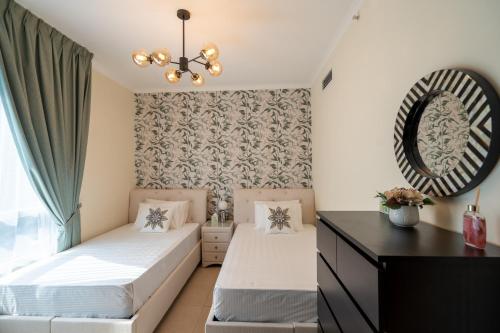 a bedroom with two beds and a mirror at INA HOMES - 2BHK Residences Tower 1 in Dubai