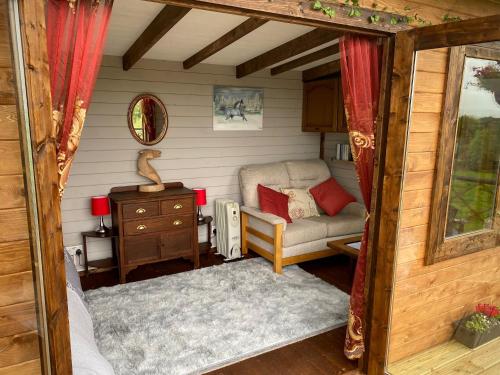a living room with a couch and a table at Cherry Tree Glamping Lodge in Wellington