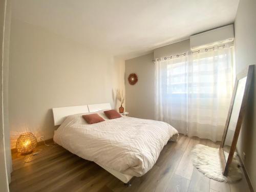a white bedroom with a bed and a window at Apartment Antibes city-center & port in Antibes