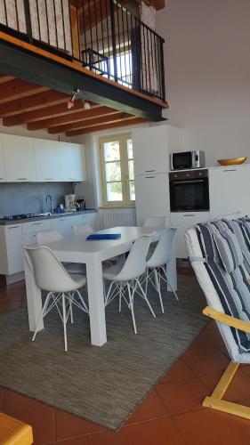 una cucina con tavolo e sedie bianchi di Appartamento Cristol a Gargnano