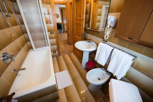 a bathroom with a tub and a toilet and a sink at Casa Guana in Livigno