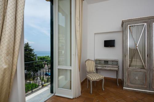 a room with a balcony with a chair and a desk at Relais San Giacomo in Maiori