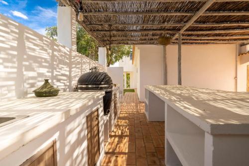 an outdoor kitchen with white counter tops and a grill at B&B Casa do Cerro in Moncarapacho