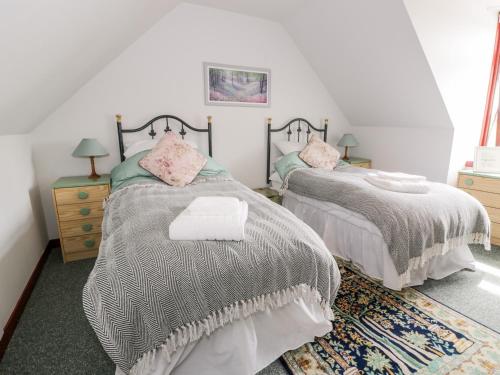 a bedroom with two beds and a rug at Shieldhill Farm House in Falkirk