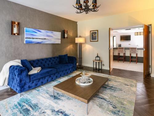 a living room with a blue couch and a table at Glamorgan House in Cardiff