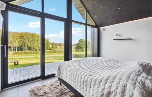 ein Schlafzimmer mit einem großen Bett und großen Fenstern in der Unterkunft Amazing Home In Hejls With House Sea View in Hejls