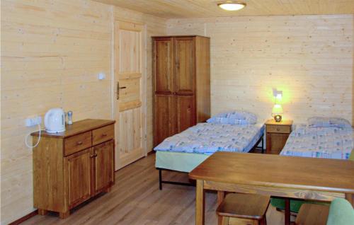 a room with two beds and a table in it at Cozy Home In Ruciane - Nida With Kitchen in Ruciane-Nida