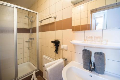 a bathroom with a shower and a sink and a tub at Haus Bliem in Flachau