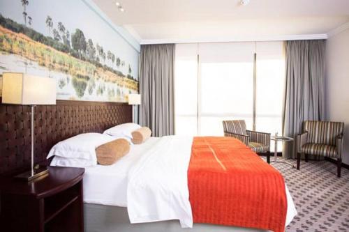 سرير أو أسرّة في غرفة في Phakalane Golf Estate Hotel Resort