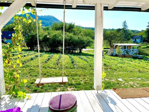 a porch swing with a view of a field at Bohemian Eco Lodge at lake Balaton in Kisapáti