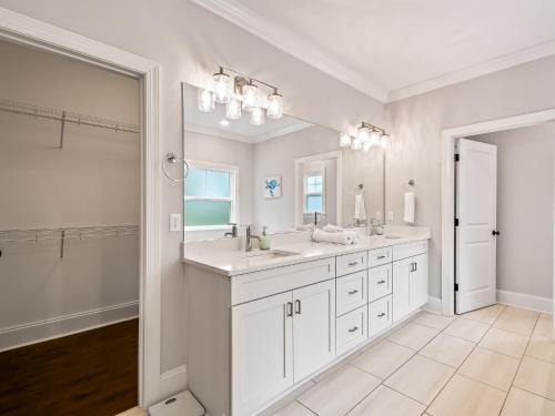 een witte badkamer met 2 wastafels en een grote spiegel bij Timber and Tides in Crawfordville